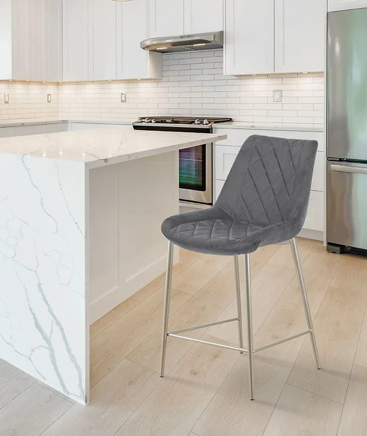 Cucina moderna con mobili bianchi, isola in marmo, frigorifero in acciaio inox e sedia imbottita grigia.