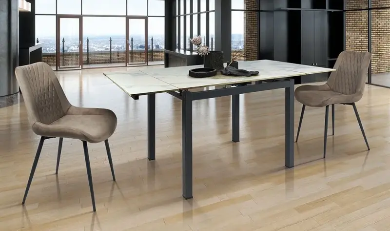 Tavolo da pranzo moderno con quattro sedie in una stanza luminosa con ampie finestre e vista sulla città.