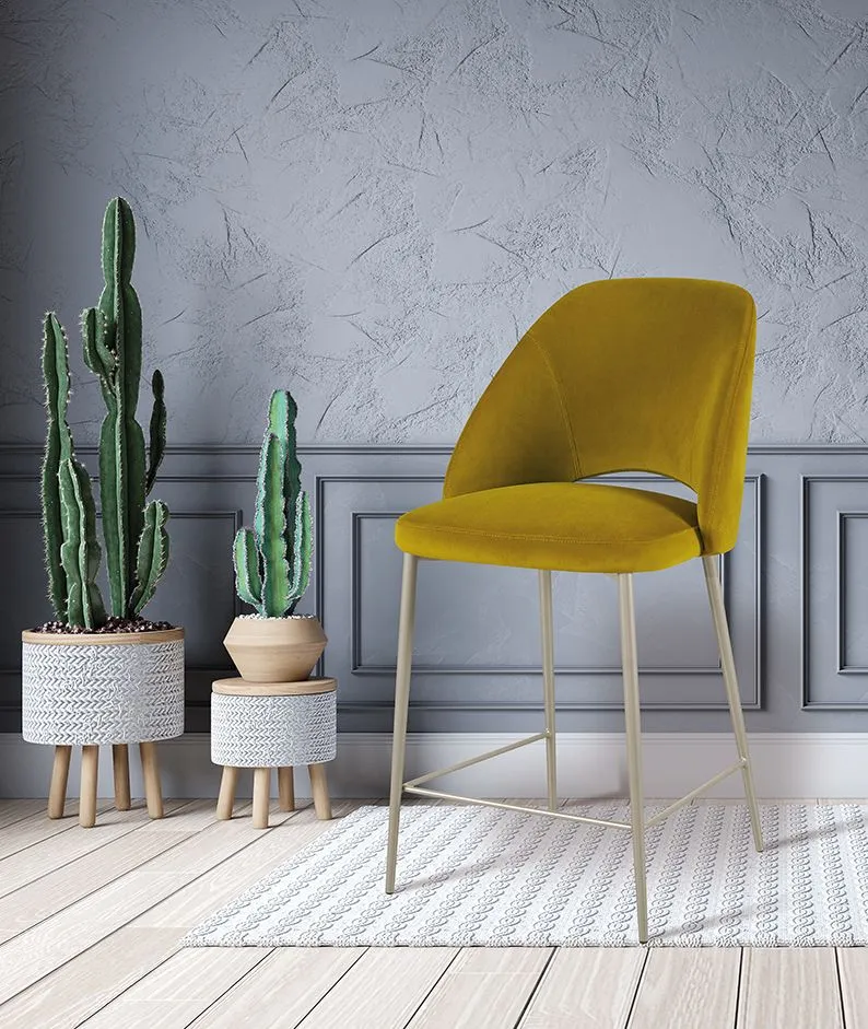 Sedia color giallo senape accanto a cactus in vaso su un tappeto intrecciato i
