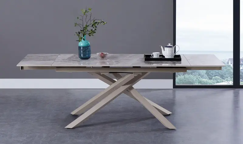 Tavolo da pranzo moderno grigio con base in legno incrociata e piccolo vaso e decorazioni sulla parte superiore.