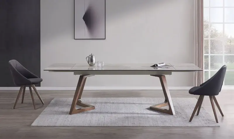 Sala da pranzo moderna con tavolo in legno, due sedie scure e un tappeto chiaro sotto un quadro minimalista alle pareti.