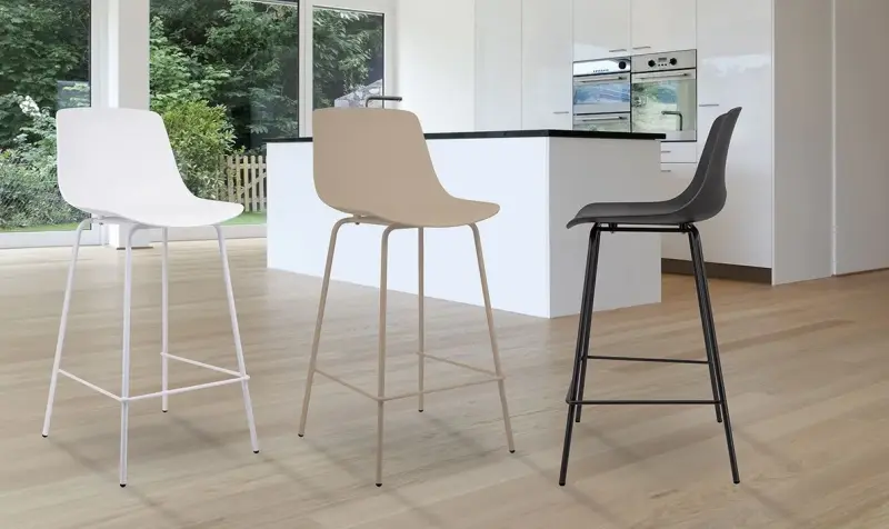 Tre sgabelli alti moderni, nei colori bianco, beige e nero, in un luminoso showroom di cucine.