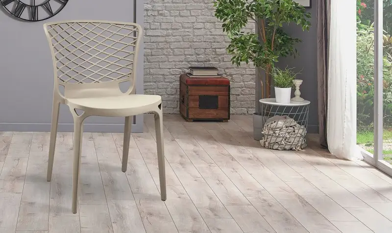 Accogliente patio con una poltrona color crema, una pianta in vaso, una lanterna.